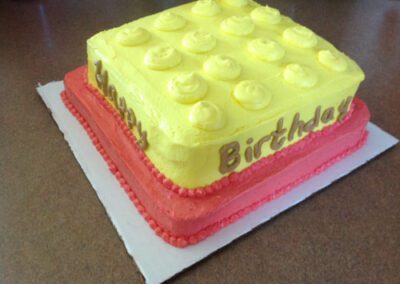 A delicious birthday cake with yellow and red frosting